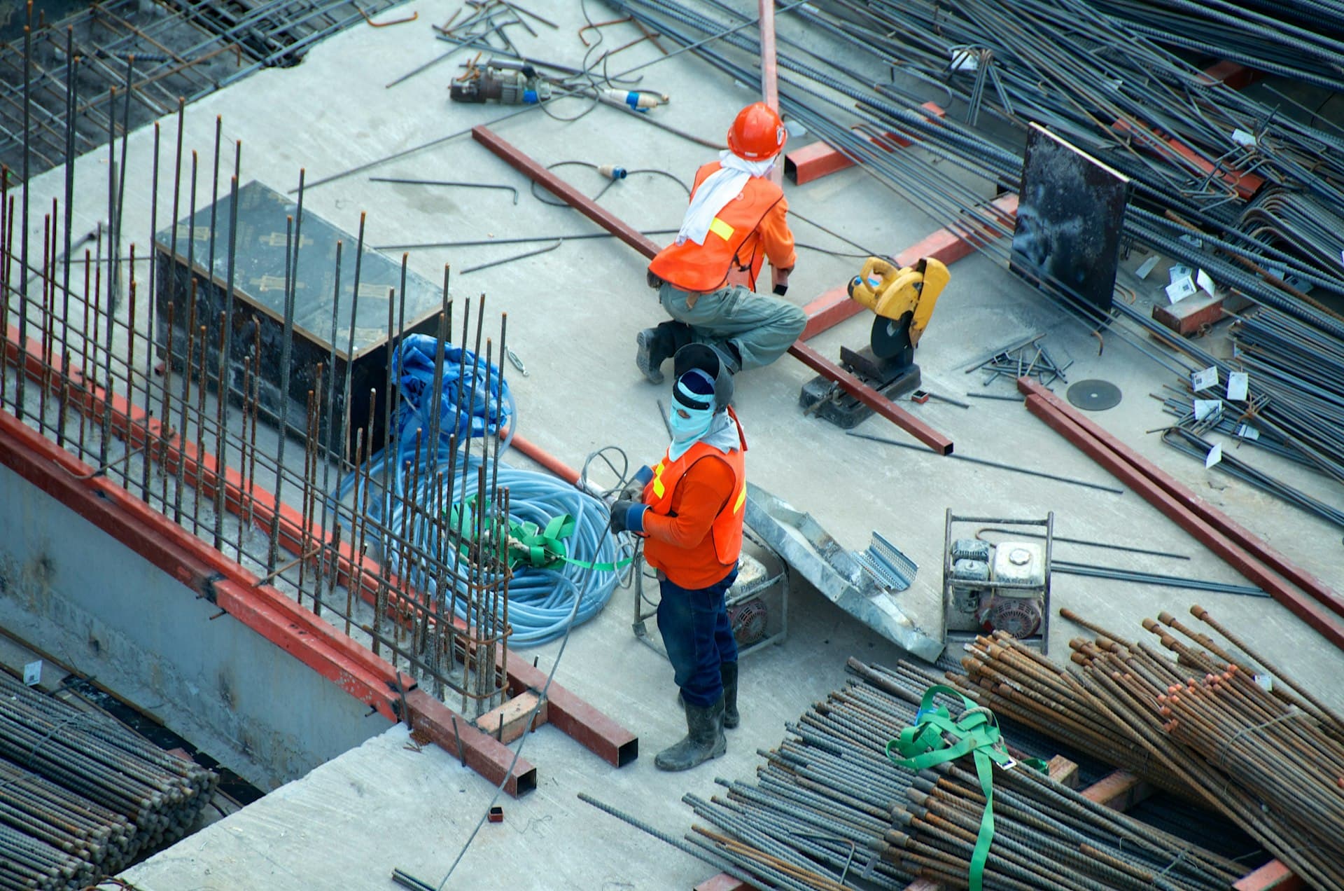 Construction workers on a high-rise steel frame at sunset